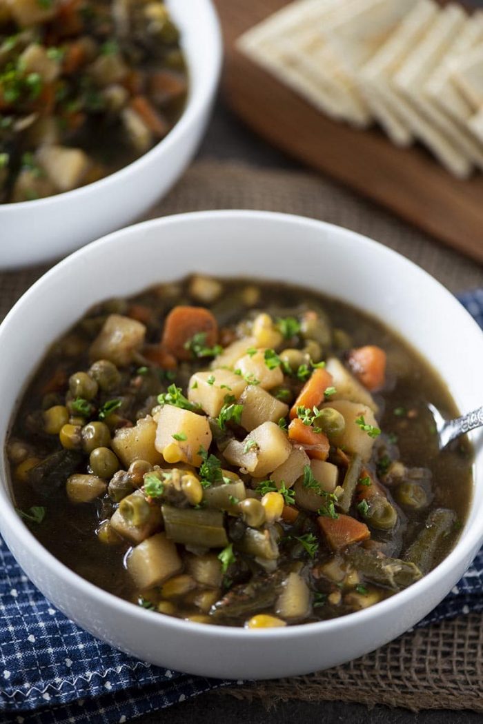 Vegetable Soup in a bowl with saltines in background