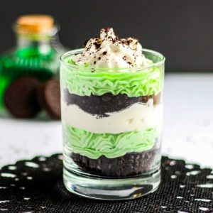 Small shot glass with mint cheese cake and oreo truffle layered in