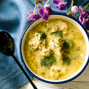 Bowl of Chicken Poblano soup on top a blue napkin with spoon
