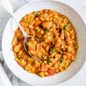 Moroccan Split Pea Soup in white bowl with spoon and white cloth napkin