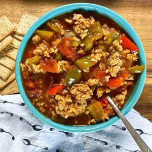 stuffed pepper soup in blue bowls with crackers and napkin