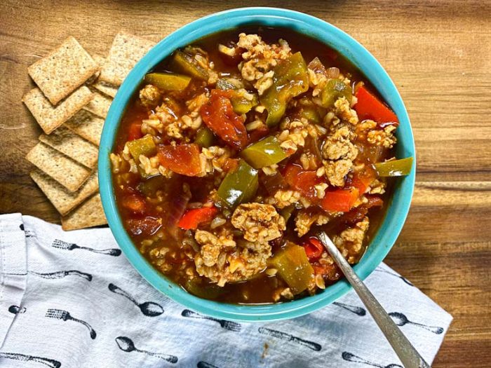 stuffed pepper soup in blue bowls with crackers and napkin