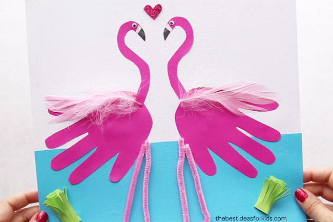 Pink handprint paper cutouts turned into flamingo crafts.