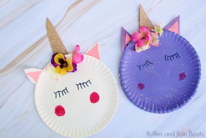 Paper plates painted as sleeping unicorns with flowers and sparkly horns.