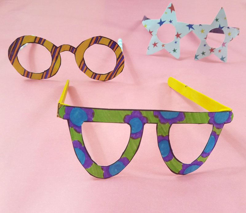 Fake glasses made from colored paper and popsicle sticks or straws.