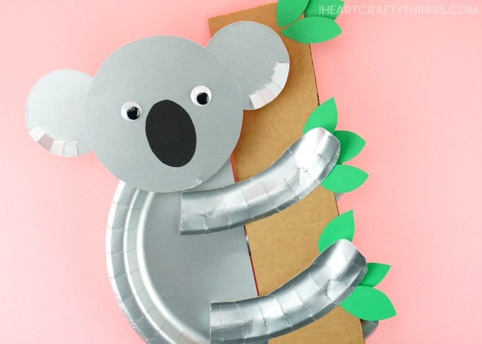 Koala craft made from paper plates hanging onto a paper bamboo tree