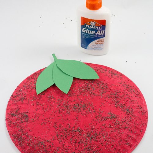 Paper plate craft painted as a strawberry with poppyseed seeds.