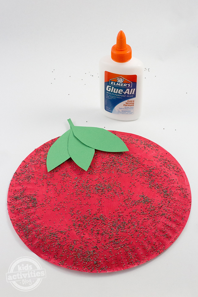 Paper plate craft painted as a strawberry with poppyseed seeds.