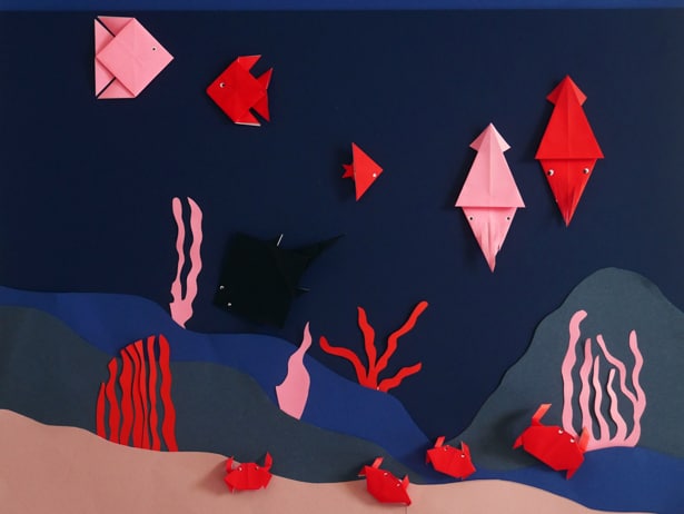 Origami sea creatures in a construction paper sea scene.