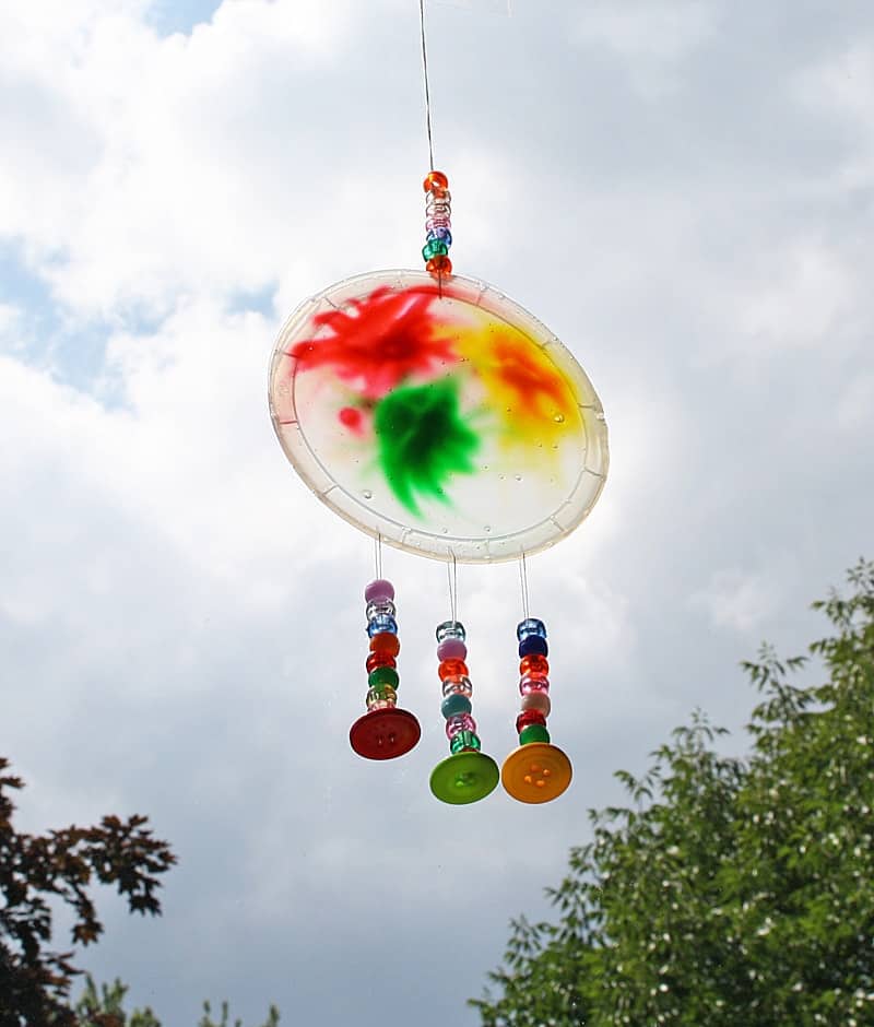 Tinted glue on plastic made into a sun catcher with added bead embellishments.