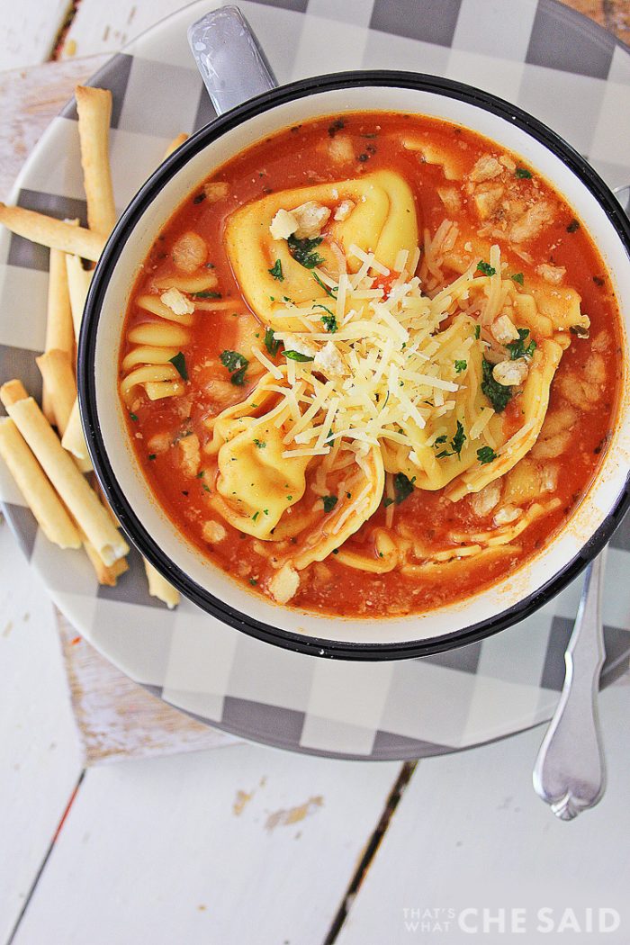 Vertical of soup on checkered plate with crispy breadsticks