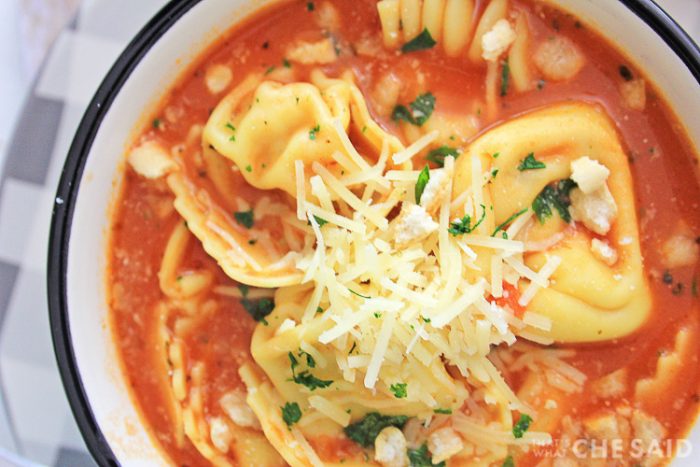 Top down shot of chicken parm soup with shredded parmesan cheese