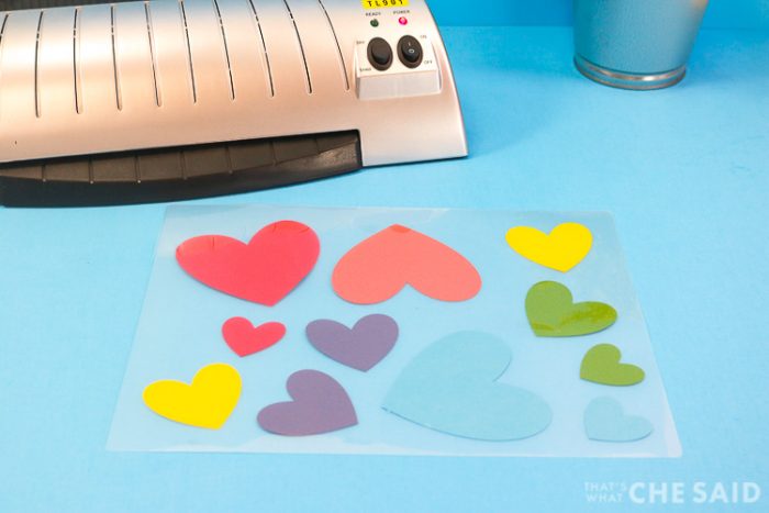 Laminator with letter sized pouch with smaller hearts placed spread out in the letter sized pouch
