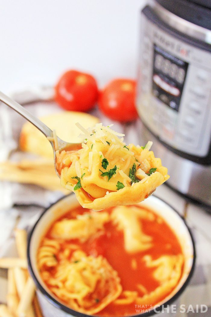 Close up of a spoon full of chicken parm soup