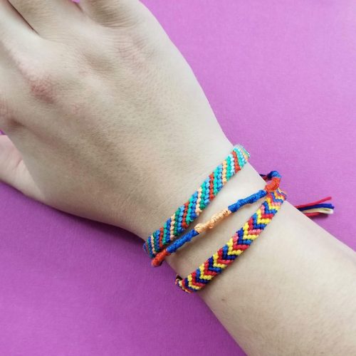 Three different friendship bracelets on a wrist.