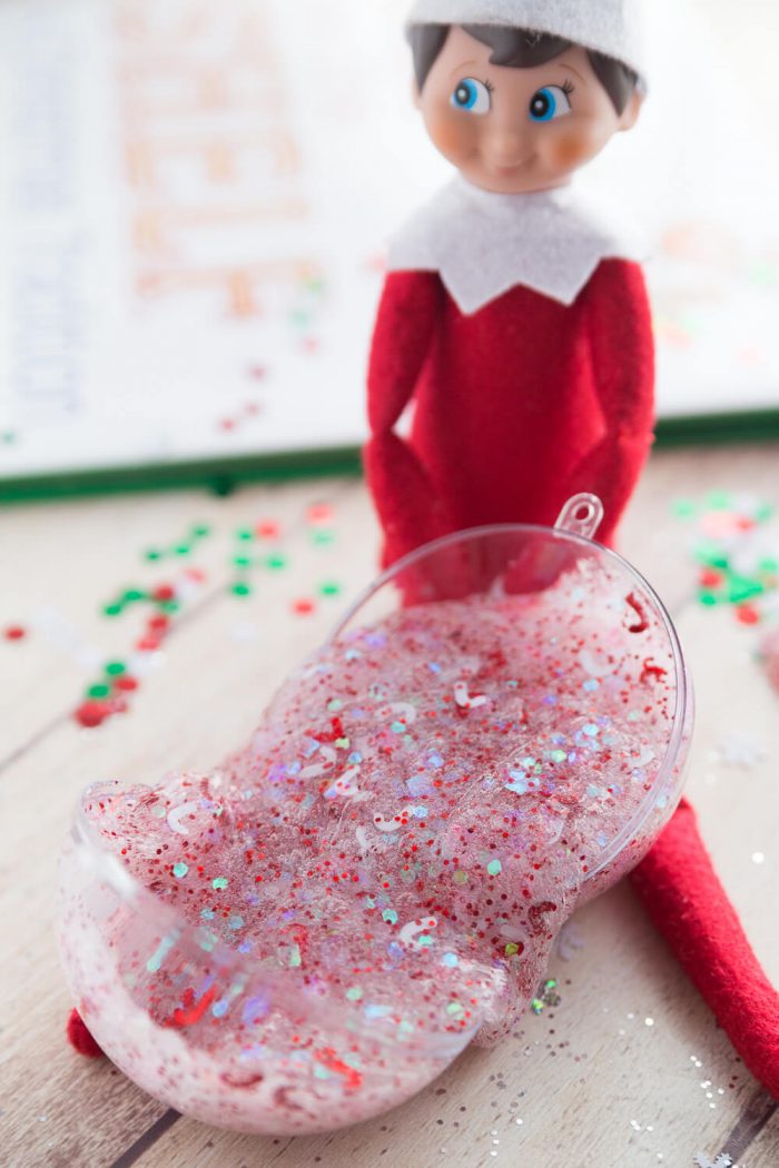 Christmas glitter in a clear slime next to Elf on the Shelf.