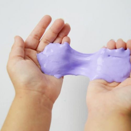 Purple gooey slime in a child's hands.