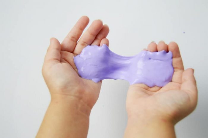 Purple gooey slime in a child's hands.