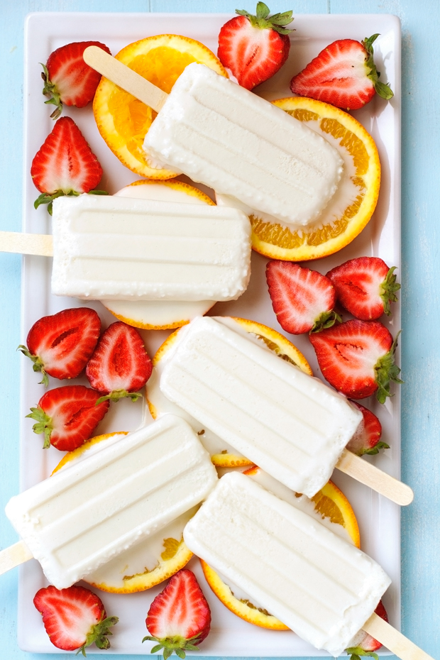 Coconut pops on a bed of orange and strawberies