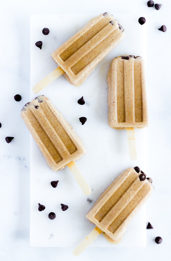 Chocolate pops with chocolate chip tops and chocolate chips strewn about