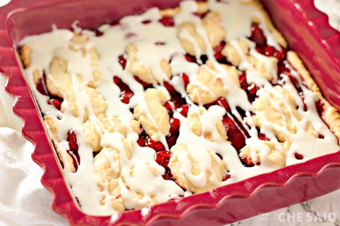 Homemade Cherry Bars in Baking Dish with frosting drizzle - Angled Shot