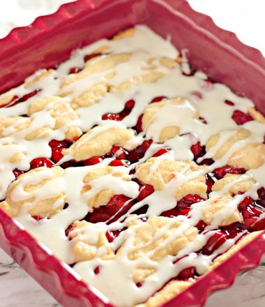 Homemade Cherry Bars in Baking Dish with frosting drizzle - Vertical Shot