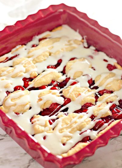 Homemade Cherry Bars in Baking Dish with frosting drizzle - Vertical Shot