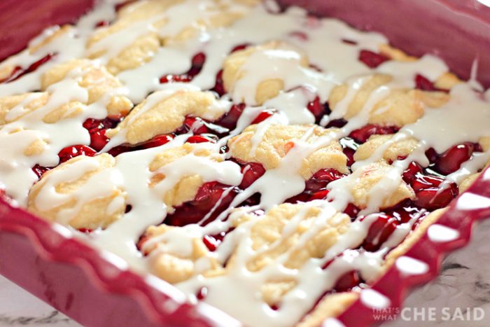 Homemade Cherry Bars in Baking Dish with frosting drizzle