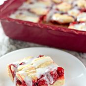 Cut cherry bar on white plate and pan of the rest in the background