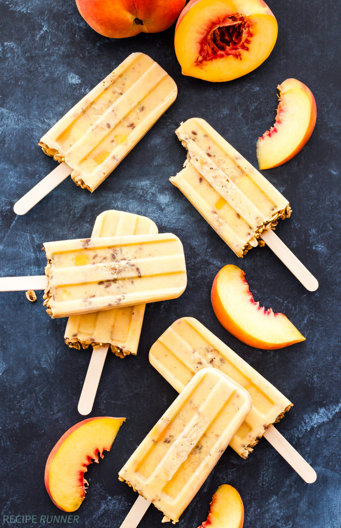 Peach Yogurt Pops on a black background with peach slices