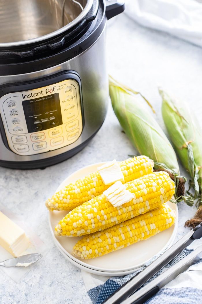 Cooked corn on the cob with instant pot in background