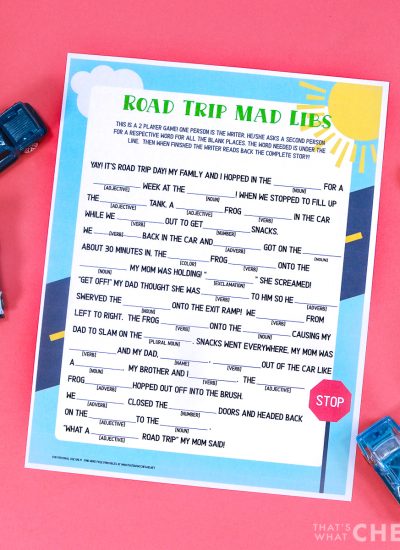 Coral background with Road Trip Mad Lib Printable and a pen and some matchbox cars Square Format