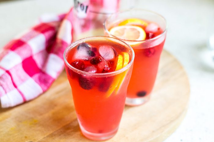 Finished product of berry lemonade garnished with lemons and berries.