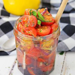 Jar full of tomato relish with buffalo check napkin behind it