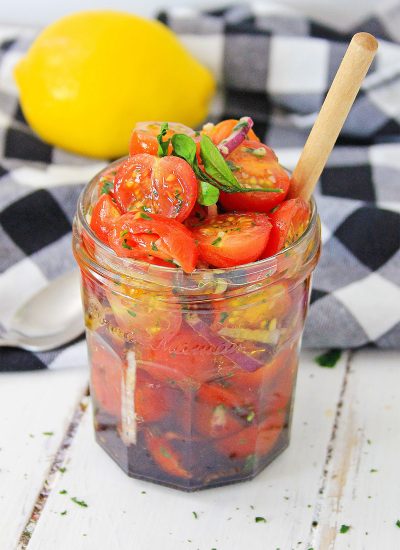 Jar full of tomato relish with buffalo check napkin behind it