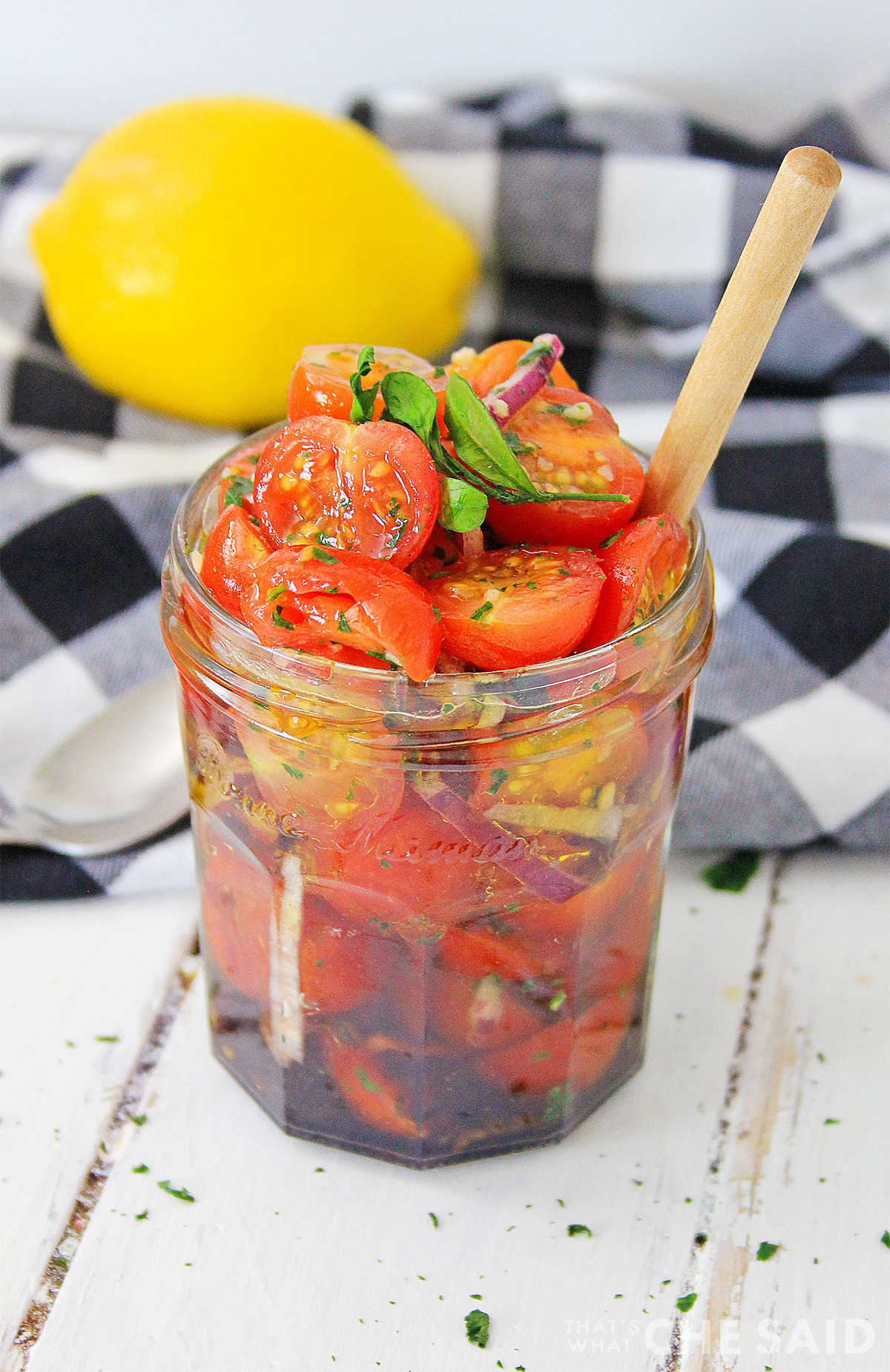 Jar full of tomato relish with buffalo check napkin behind it