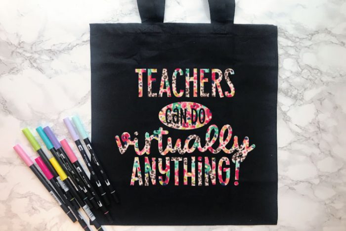 Black Tote Bag with some Tombow Markers and "Teachers Can Do Virtually Anything" in patterned floral leopard iron on in horizontal format