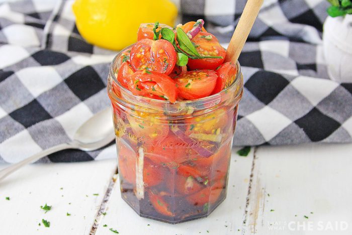 Jar full of tomato relish with buffalo check napkin behind it