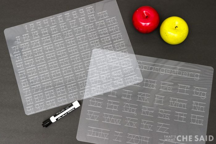 Dollar store plastic cutting mats turned Alpha and Numeric tracing mats using a Cricut Machine - Horizontal shot both mats on black "chalkboard" background