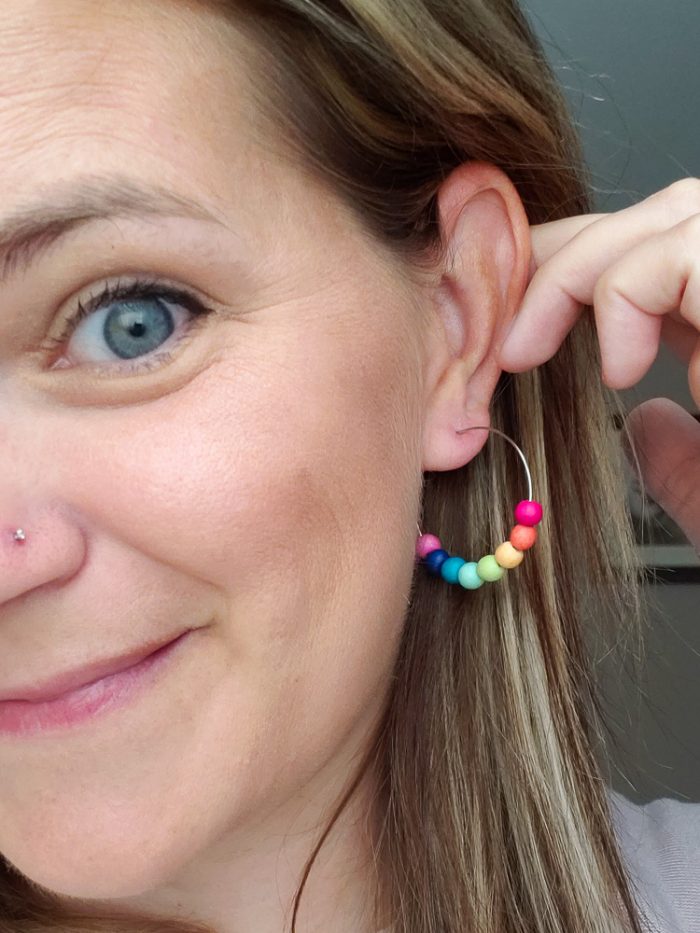Close up of Cheryl modeling rainbow earrings from leafytreetop