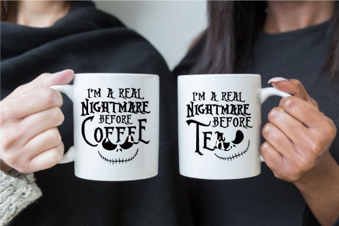 Man and Woman holding white coffee mugs together. Coffee mugs read "I'm a Real Nightmare Before Coffee" and "I'm a Real Nightmare Before Coffee"