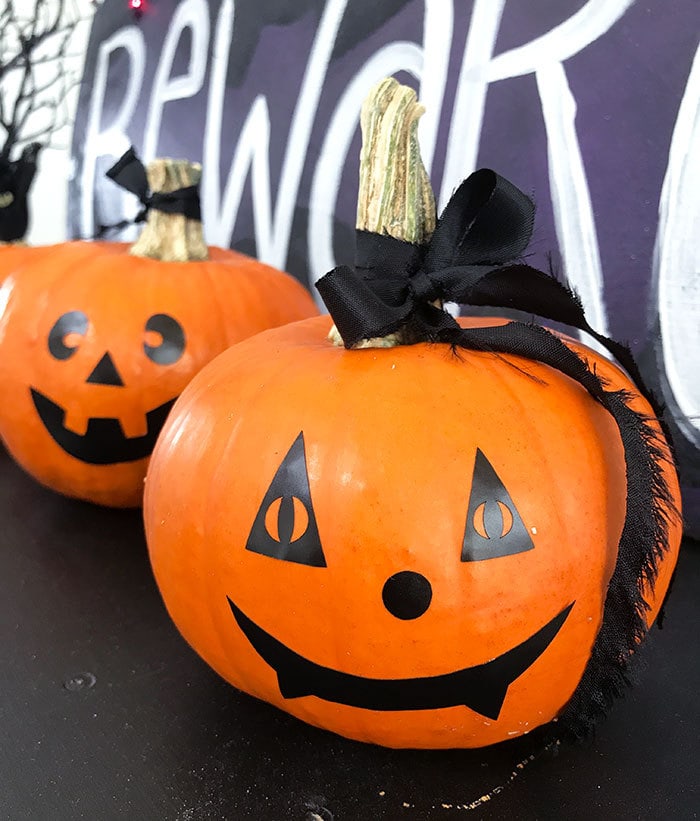 Faces made with adhesive vinyl on pumpkins