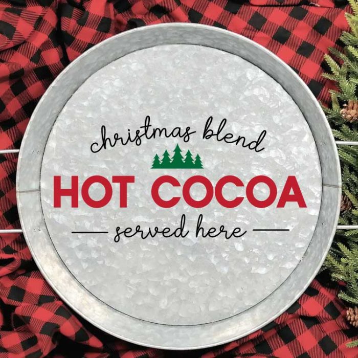 Galvanized Serving Tray with "Christmas Blend Hot Cocoa Served Here" SVG applied in adhesive vinyl on a red and black buffalo check blanket with some greenery in square format