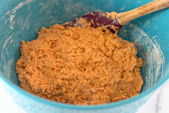 Wet and Dry ingredients combined in blue bowl to form a pumpkin donut dough