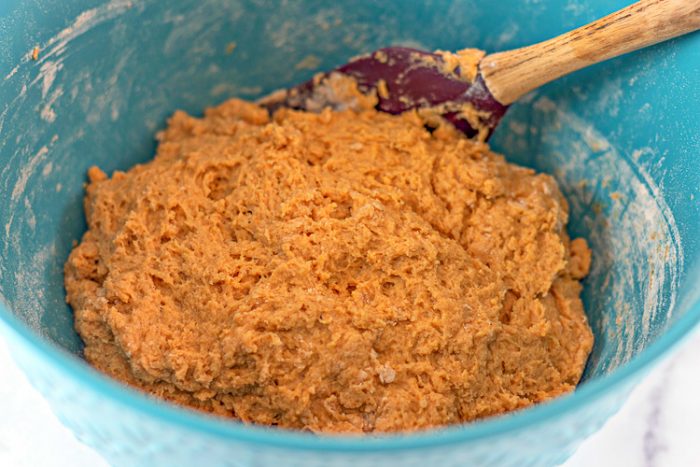 Wet and Dry ingredients combined in blue bowl to form a pumpkin donut dough