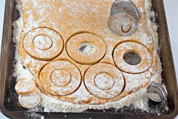 Pumpkin donut dough rolled out and cut using 2 sizes of biscuit cutters