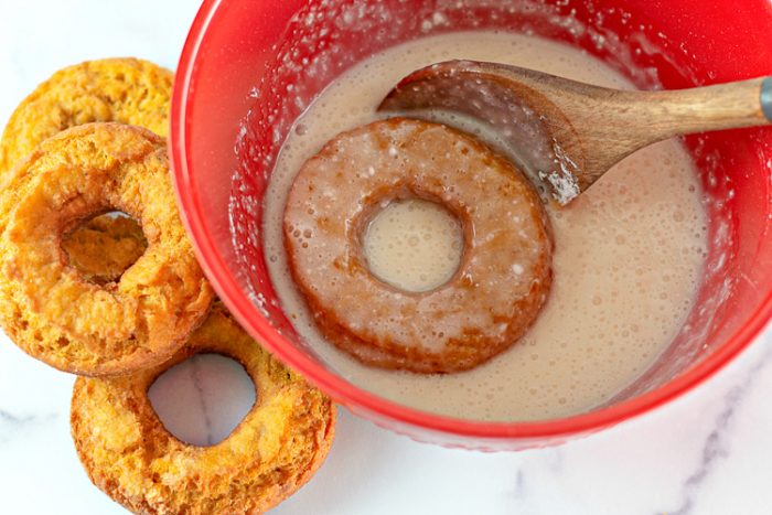 Adding glaze to pumpkin donuts