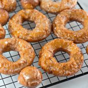 Pumpkin donuts and pumpkin donut holes on a black wire cooling rack