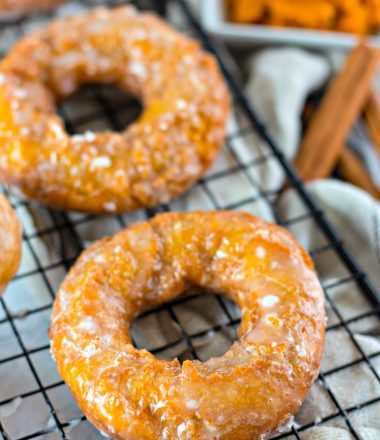 Close up of Pumpkin donuts on a black wire cooling rack