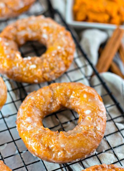 Close up of Pumpkin donuts on a black wire cooling rack